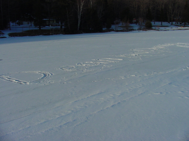 There is about half an inch of snow on the lake.  Just the right amount to scrawl taunts in to passing planes.