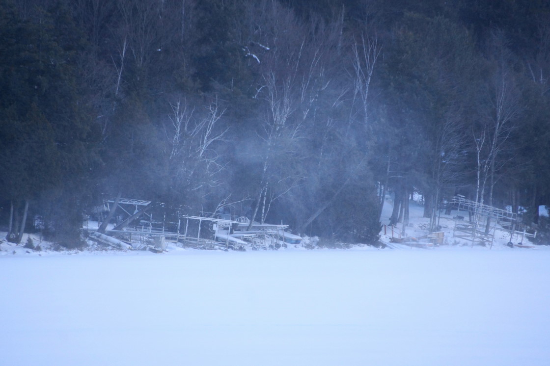 When it wasn't snowing, it was winding. Snow devils whirled down the lake, stinging any exposed flesh in its path and making drifts.