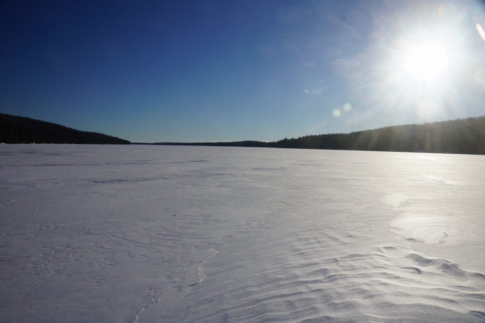 Thus far, it's been a dry Winter. Ultra cold, but not much snow. Snow dependent activities have had to depend on residual snow and the occasional flurry. The 27th Annual Lake Lucerne Bottle Rocket War was no exception. Much of the lake's playing surface was snowless. Strong winds had picked up the white and deposited it on the shore and the occasional sculpted snow dune. That would have to do.