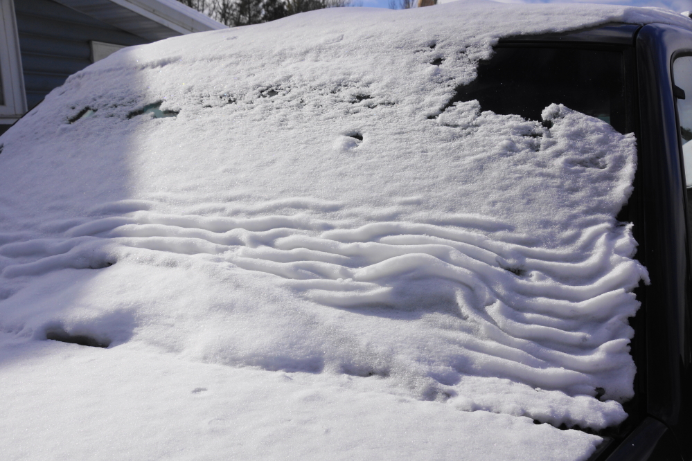 The sun warmed the inside of vehicles. The outside cold kept snow cover from melting. This resulted in several cars and trucks being 